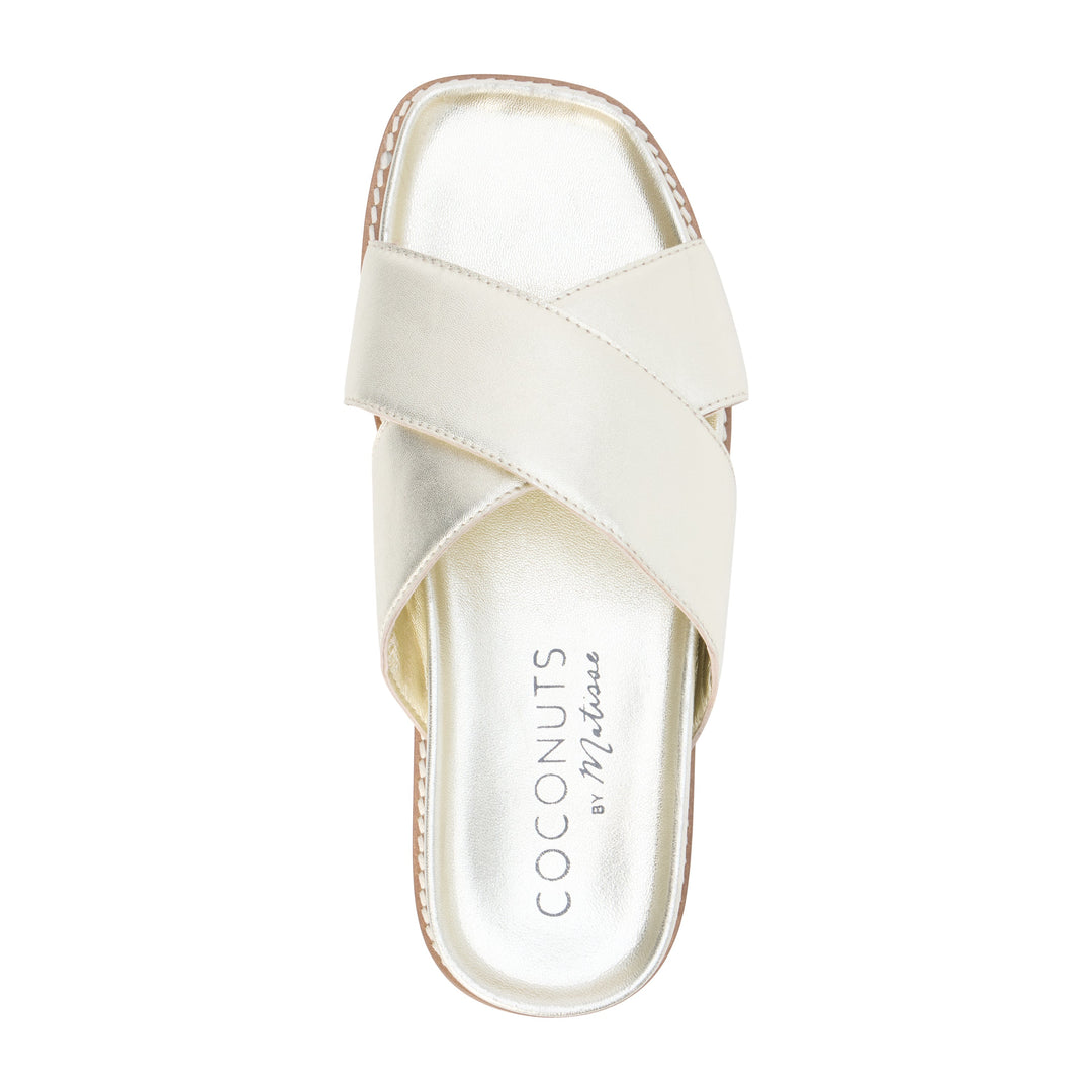 Gold sandal with 'Coconuts by Melissa' branding on a white background